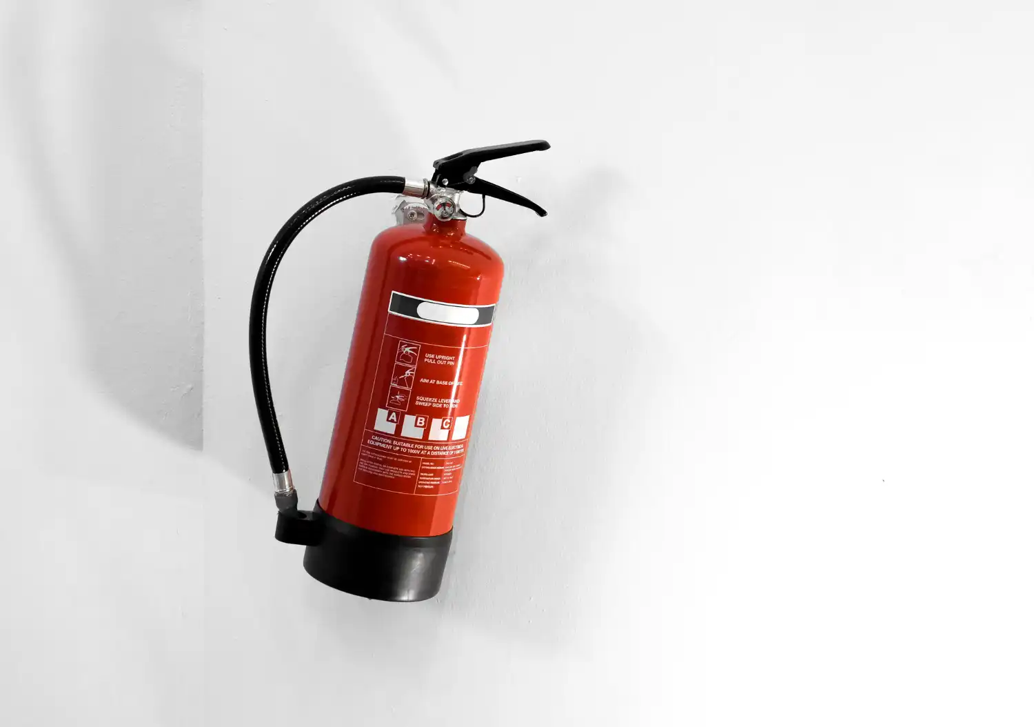 Imagem de um extintor de incêndio vermelho, utilizado na manutenção de extintores para proteger imóveis e funcionários, essencial para o planejamento financeiro empresarial.